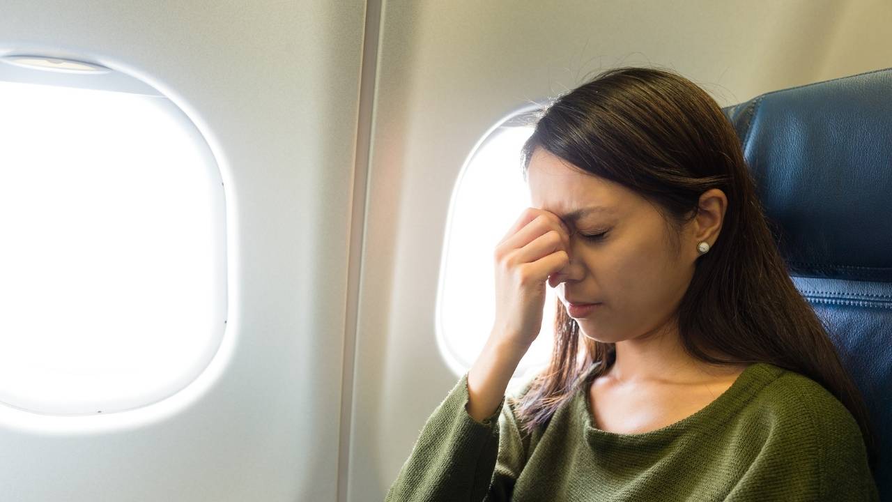 zena zmuri u avionu i trudi se da ne pokaze strah od letenja